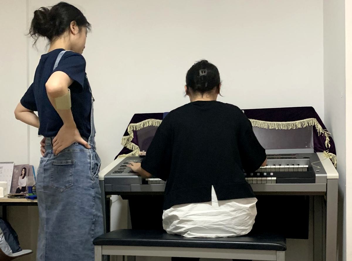 教師於紅磡工作室一對一指導學生彈奏雙排鍵